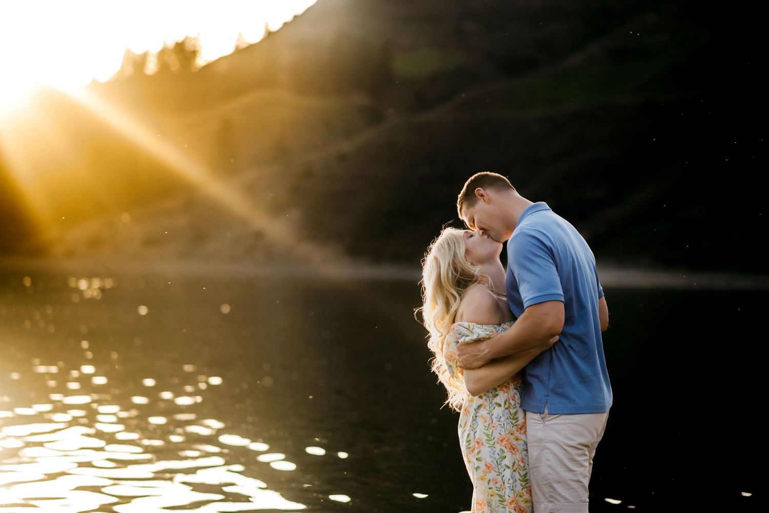 Couple kissing while the sunsets behind the mountain and river in Spokane, Washington