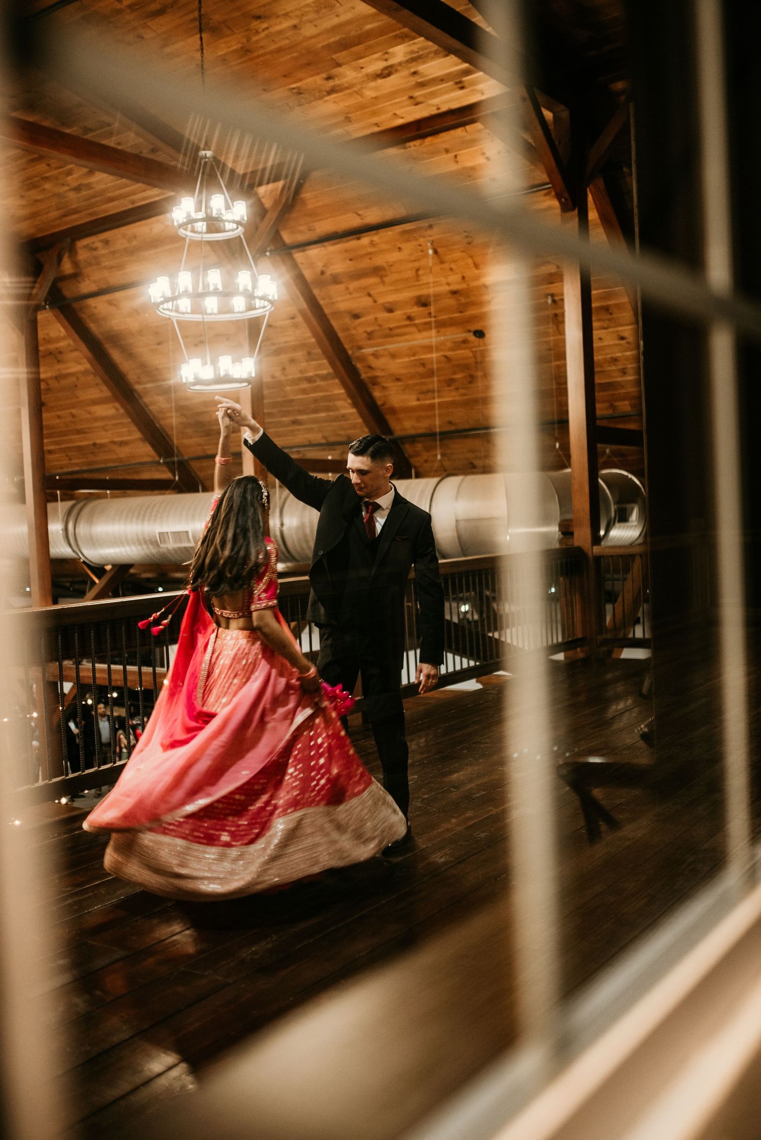 Fort Campbell Groom twirling his bride during a dance at the Venue in Clarksville, Tennessee while photographer takes a picture.