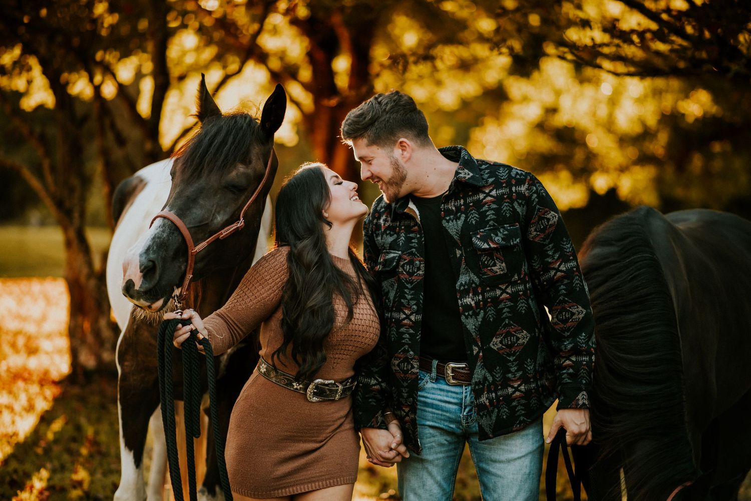 A couple about to kiss each other while holding their horses during fall time in Clarksville TN.