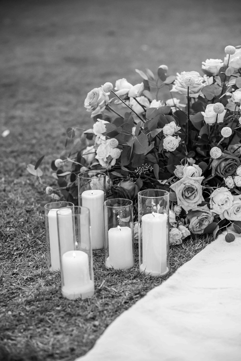 Black and white photo of roses and candles creating a romantic wedding setting.