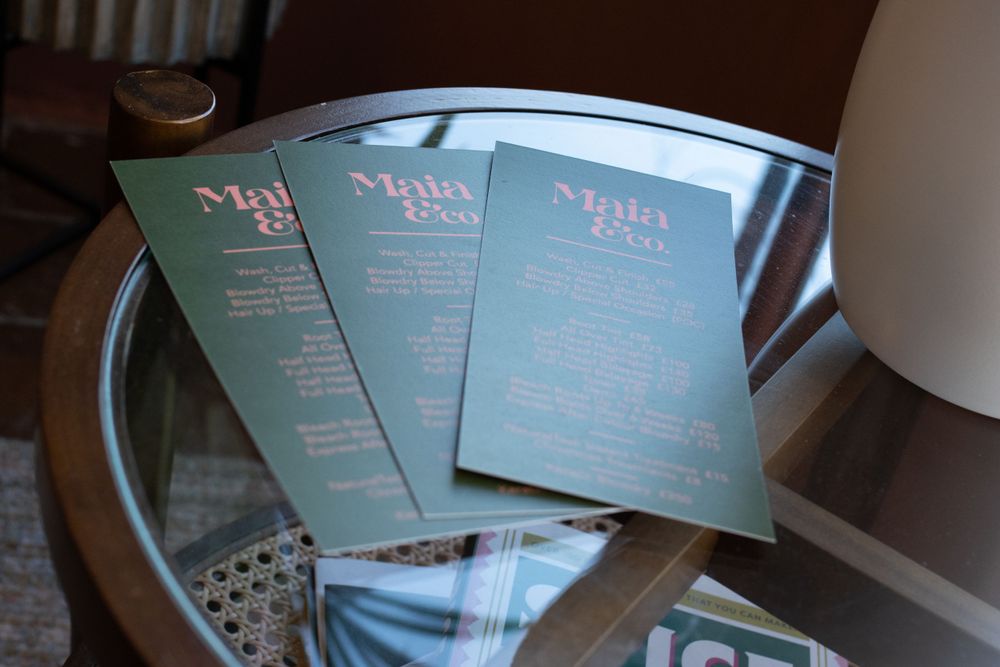 Three mint-colored menus or service cards displayed on reflective surface.