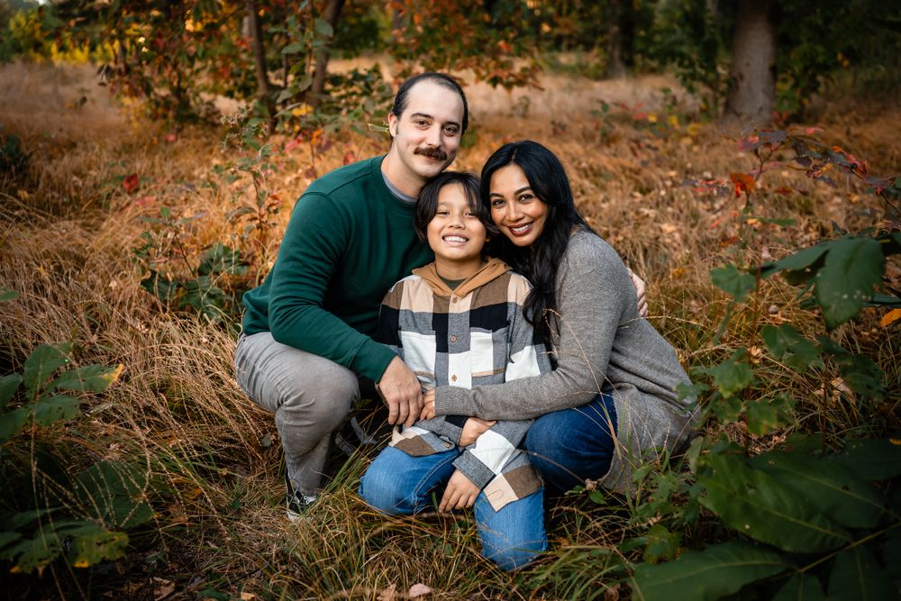 Intimate family portrait in autumn forest with warm evening light.