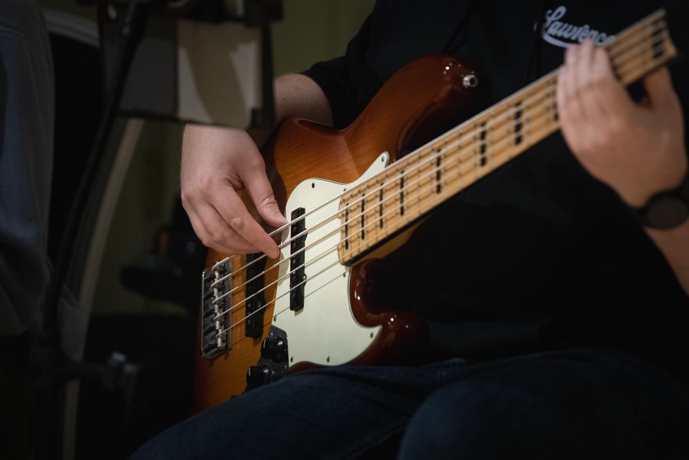 Brown and white guitar with hands in view as its being played. Event photography Shot in Blackwood, South Wales