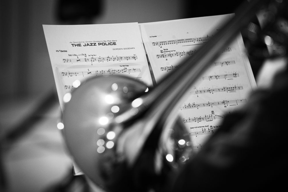 A black and white image of a music sheet in focus behind a unfocused trumpet in the forefront. Captured in Newbridge, South Wales