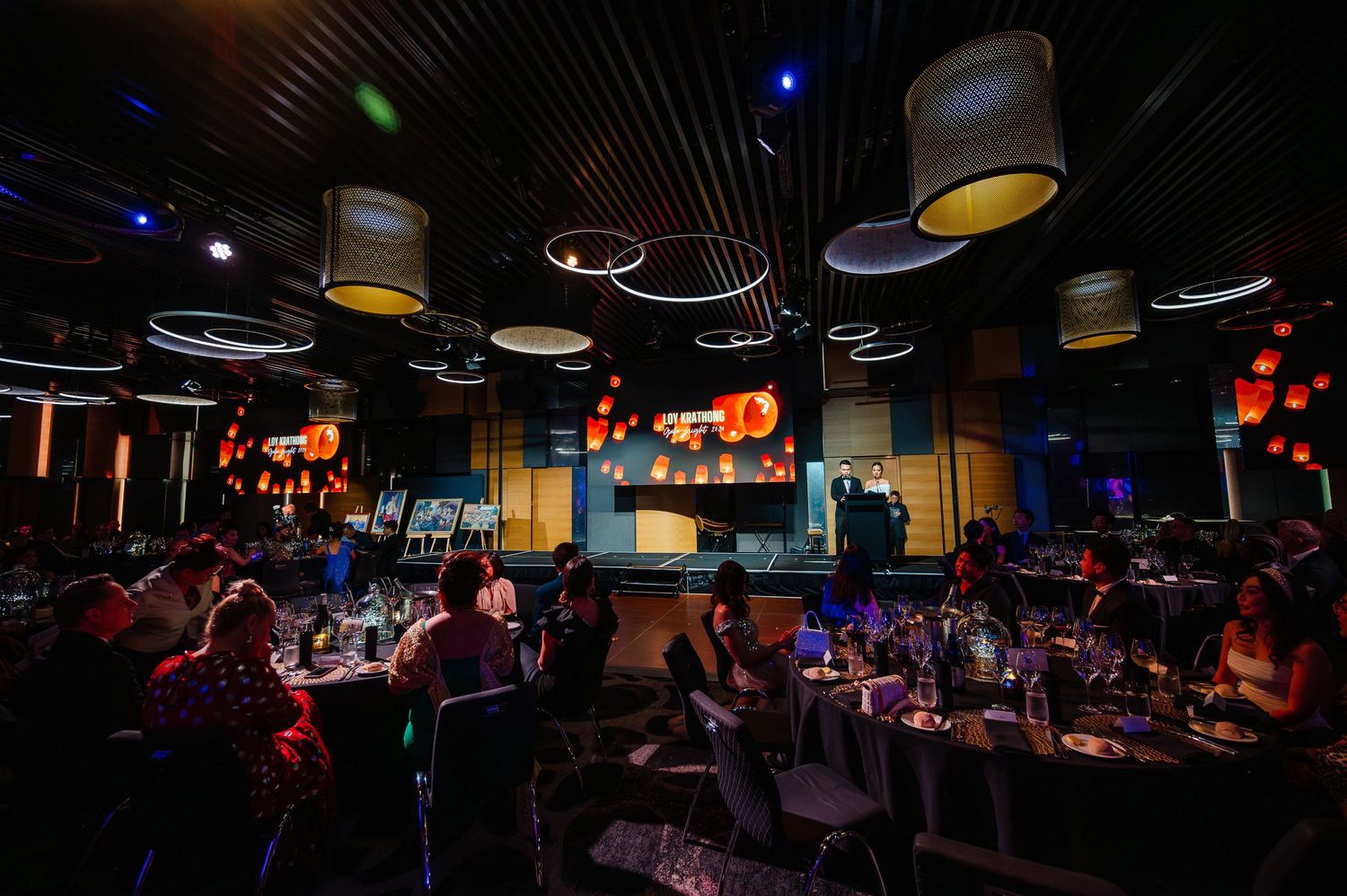 Atmospheric dining room with modern ceiling lights and ambient blue lighting.