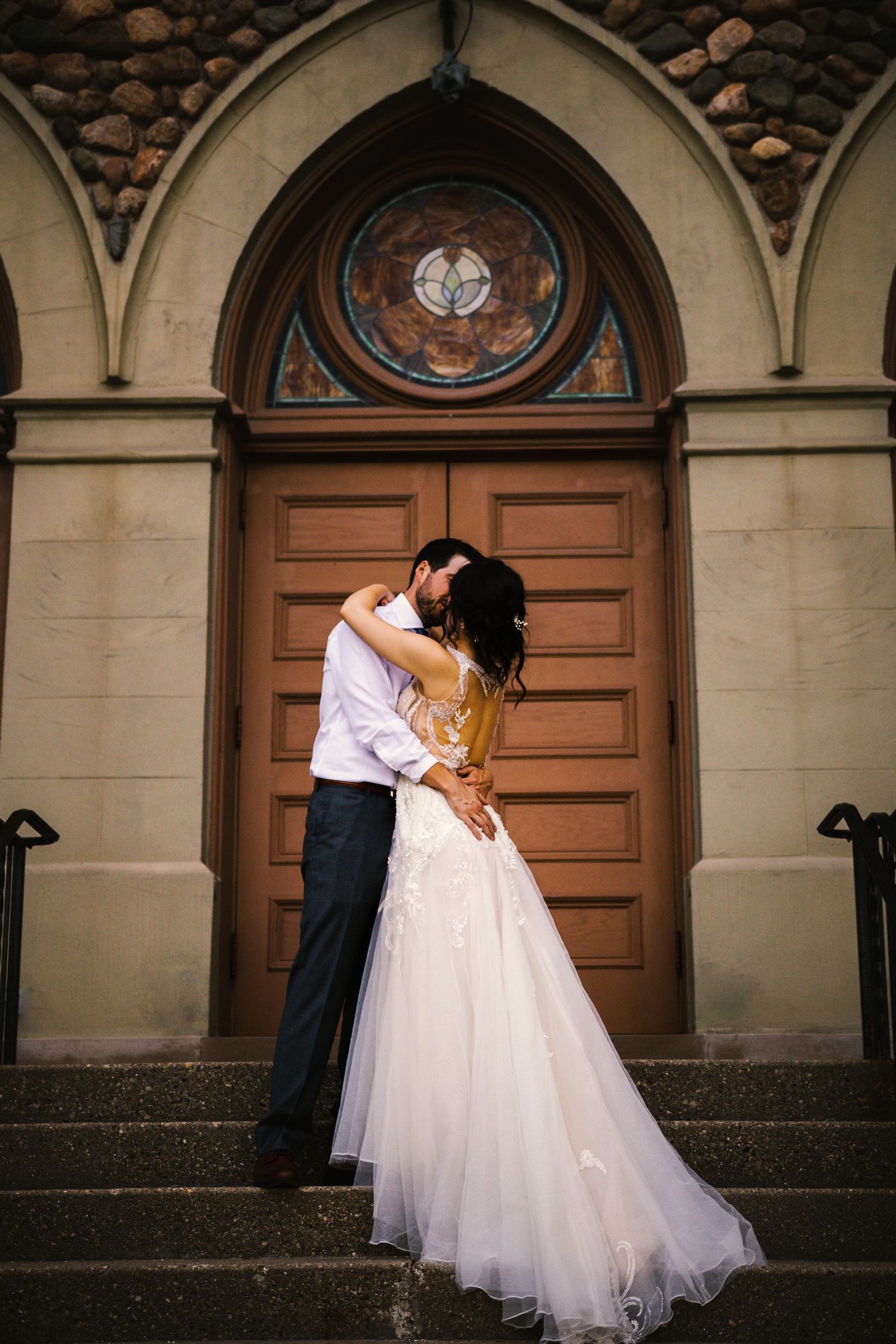 A wedding portrait of a couple in front of a church in Michigan
