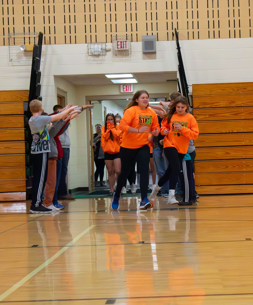 Prairie Farm Wisconsin Cross Country team 2024 running into the gym for the Pep Rally Introduction.