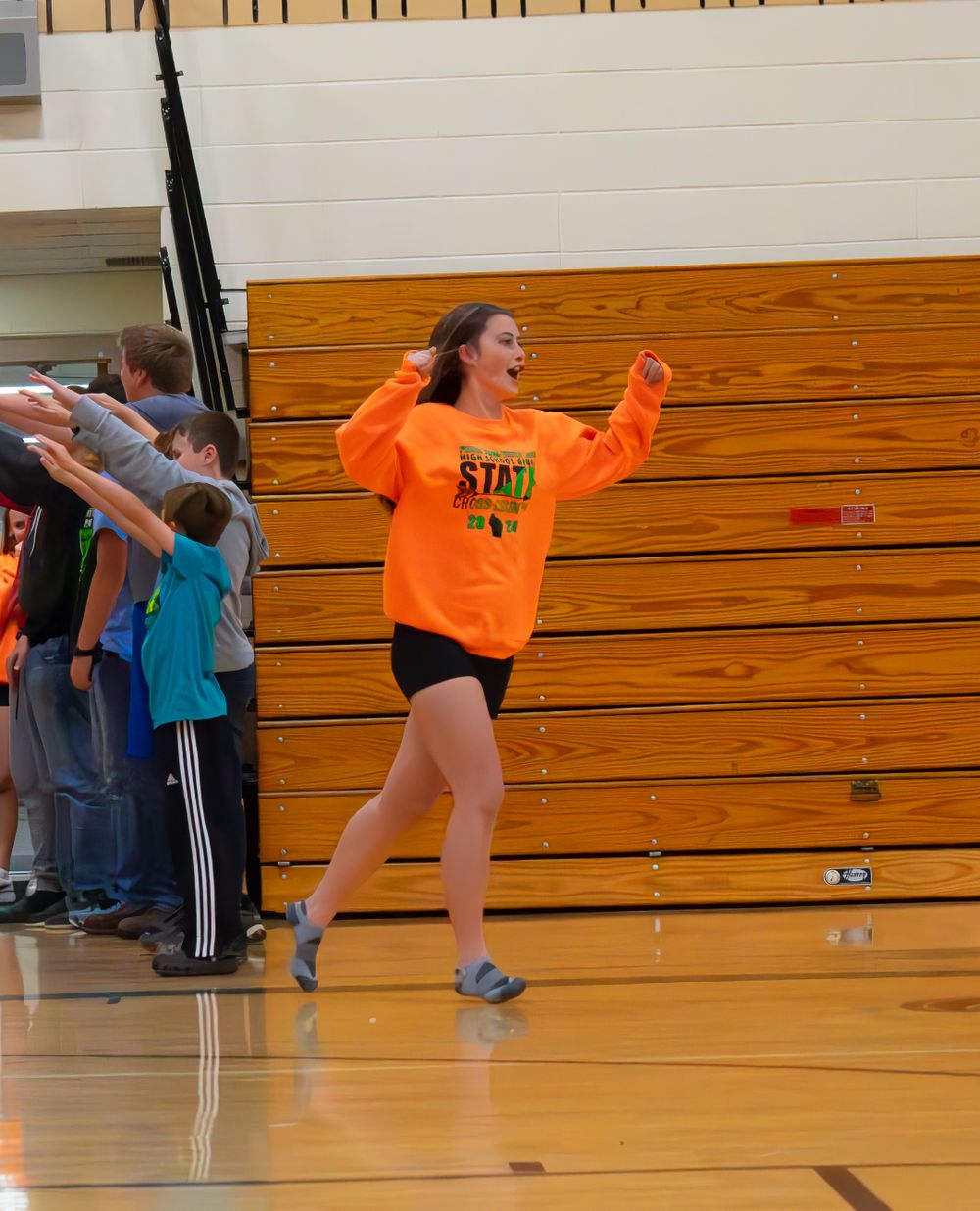 Alexa Moret, member of the Prairie Farm Wisconsin Cross Country team 2024 running in for the Pep Rally cheering in excitement.