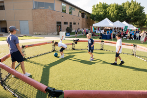 Children play in an outdoor recreational area with game equipment.