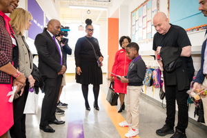 Group of people standing in colorful hallway during school or facility tour.