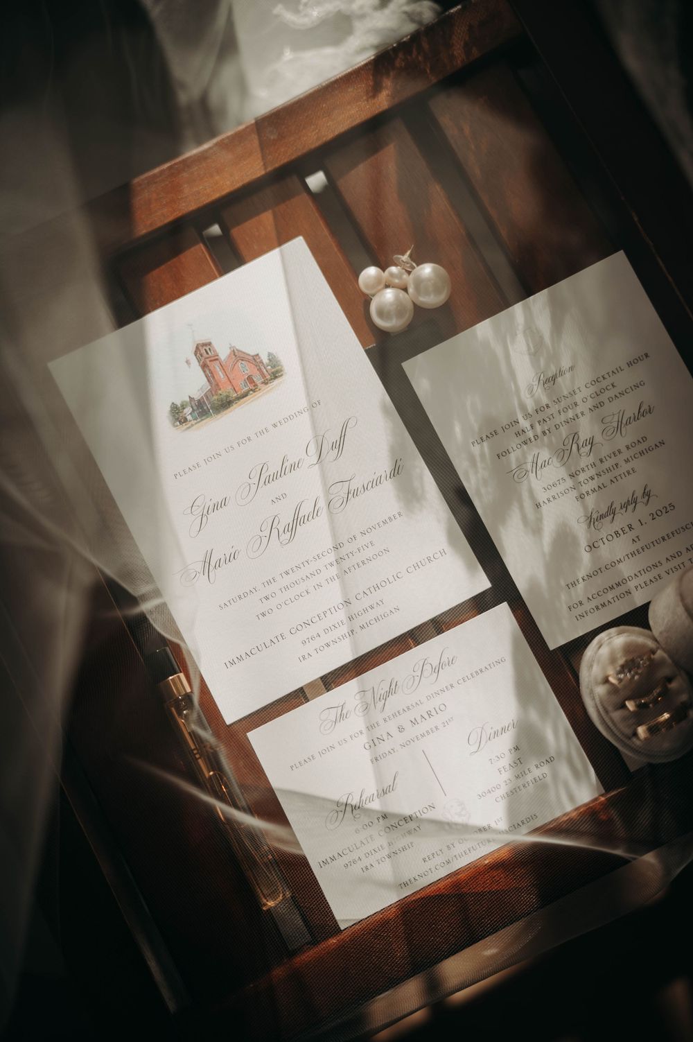 Sunlit wedding invitation suite featuring church illustration, pearl drop earrings, and ring box.