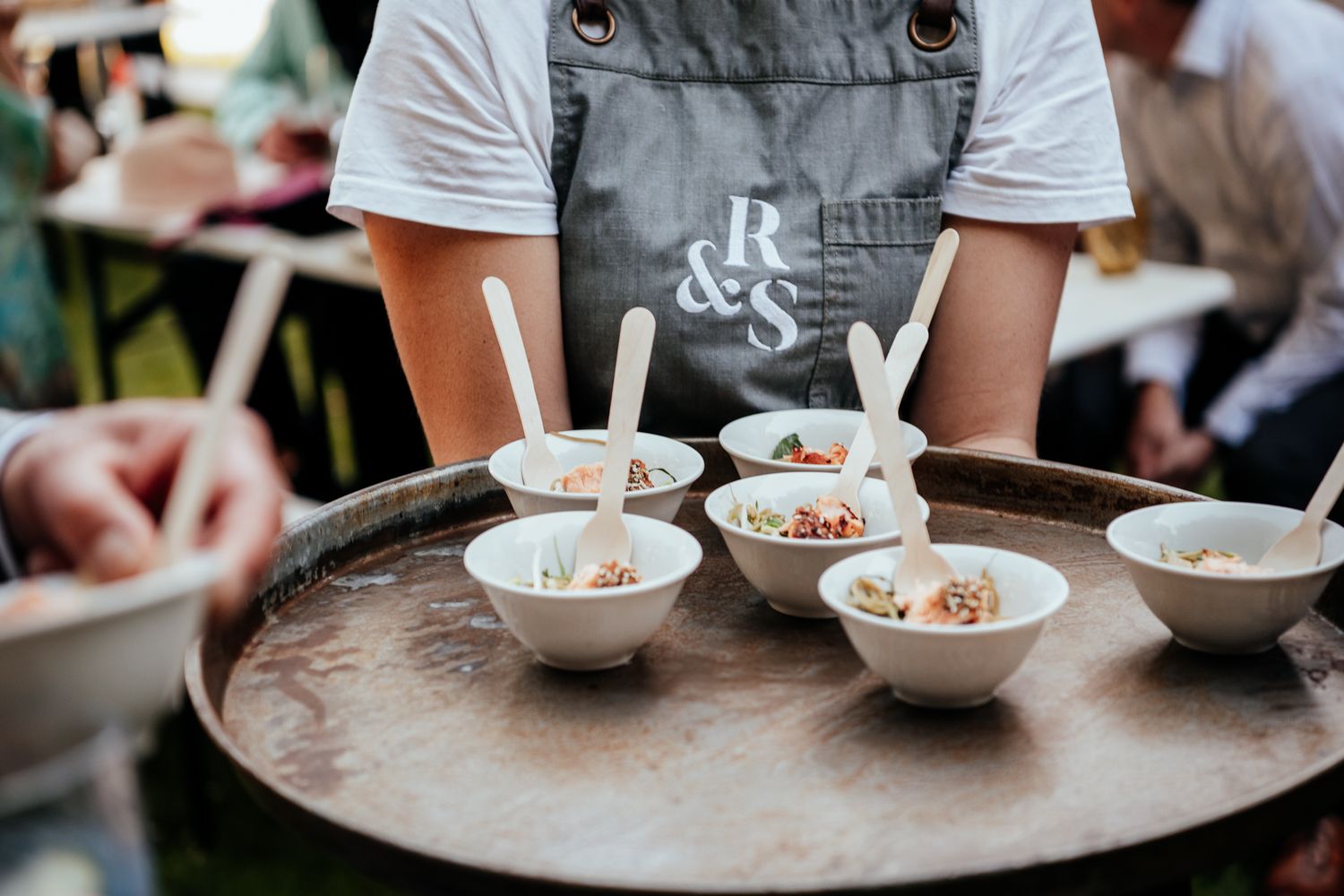 Waitress at Rose and Smith holds a tray of canapés in small bowls captured by August and Vine