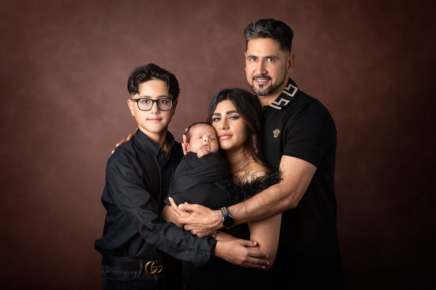 A series of six dark-toned professional portrait photographs showing intimate family moments in matching outfits.