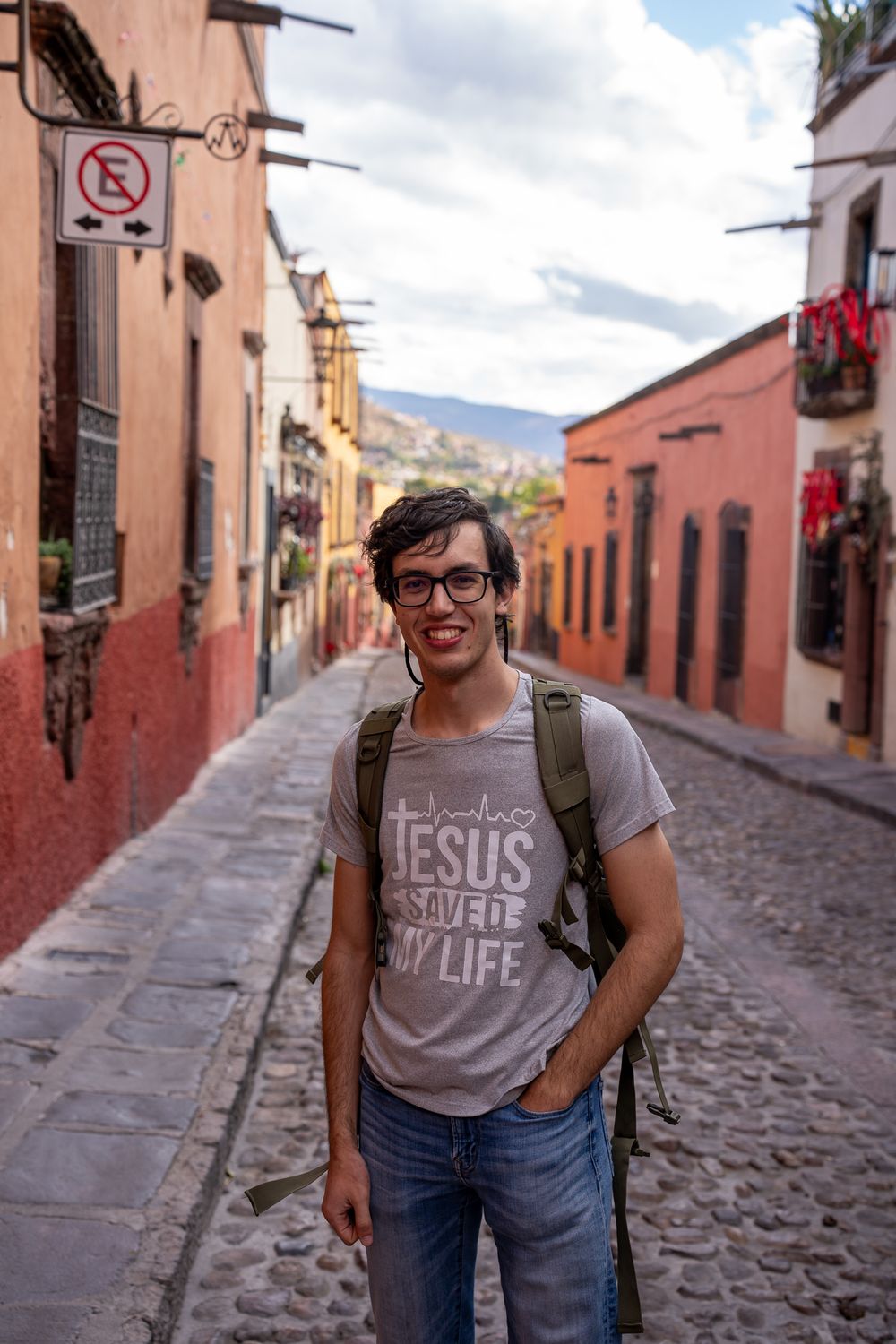 A tourist explores the colorful colonial streets of San Miguel de Allende, Mexico with historic buildings and cobblestones.
