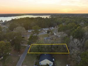 Aerial sunset view of residential neighborhood with yellow property line markers visible.