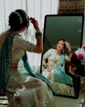 A series of reflective shots showing someone in an ornate turquoise and gold traditional South Asian dress.