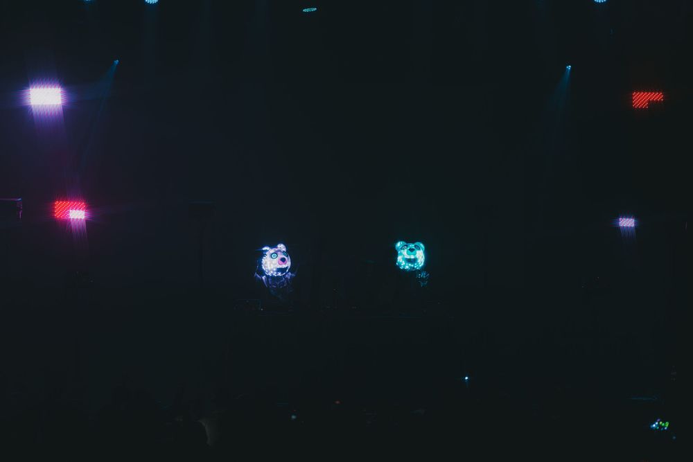 Glowing neon lights illuminate a dark room with scattered blue and pink dots creating an atmospheric ambiance.