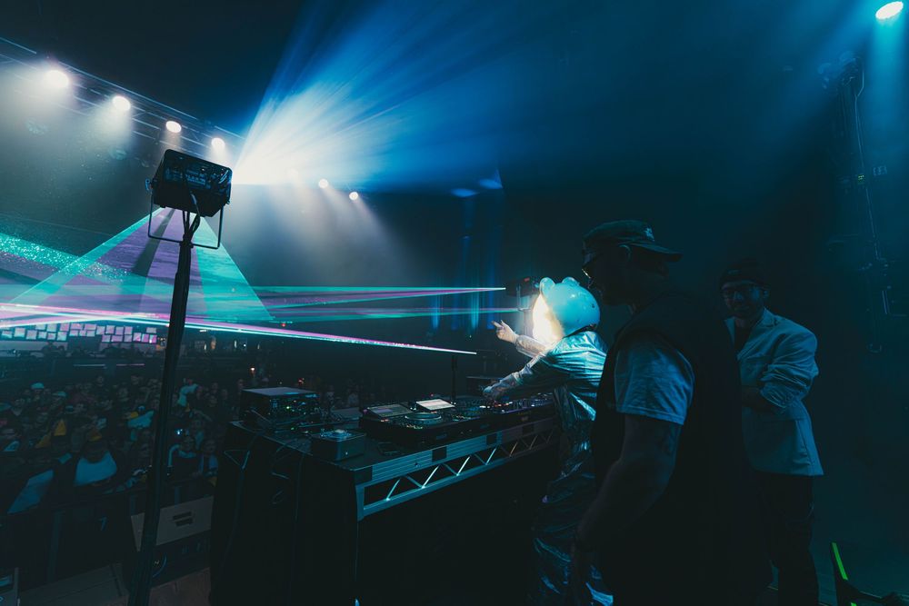 Concert stage illuminated with dramatic blue lighting and fog effects during a live performance.