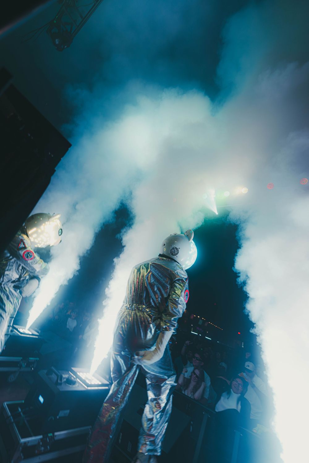Atmospheric concert scene with dramatic blue lighting and fog effects creating a moody silhouette on stage.