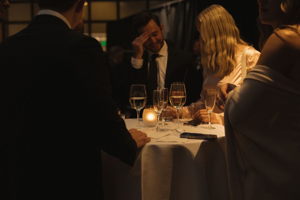 Diners enjoy an intimate candlelit dinner with wine glasses at an upscale restaurant table.
