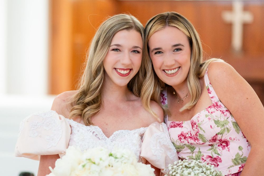 Two people in formal attire smiling together in an elegant indoor setting.