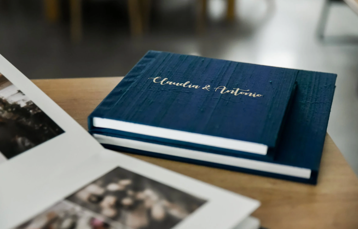Stack of elegant tan leather photo albums arranged on dark green velvet fabric.