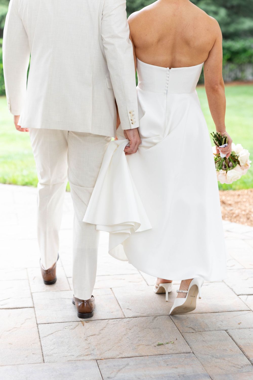 Four detail shots of wedding attire showing white shoes and dress hemlines walking on stone pavement outdoors.