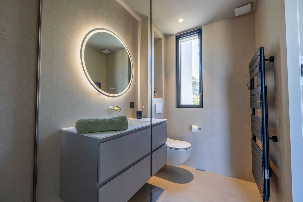 Salle de bain luxueuse avec douche à l’italienne, matériaux haut de gamme et finitions élégantes, photographiée par un photographe immobilie