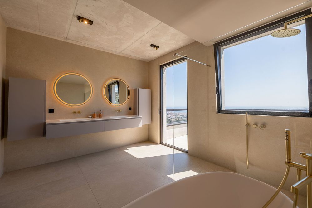 Salle de bain luxueuse avec douche à l’italienne, matériaux haut de gamme et finitions élégantes, photographiée par un photographe immobilie