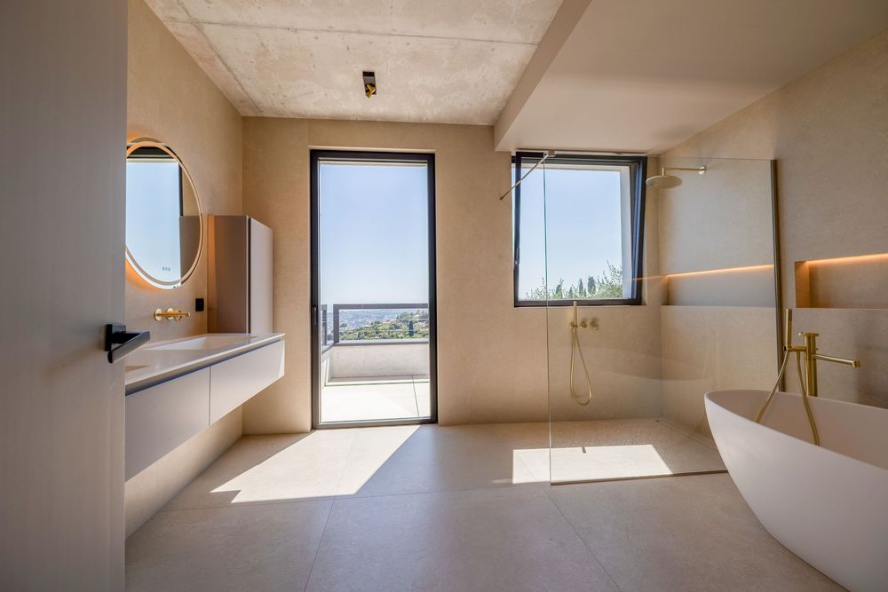 Salle de bain luxueuse avec douche à l’italienne, matériaux haut de gamme et finitions élégantes, photographiée par un photographe immobilie