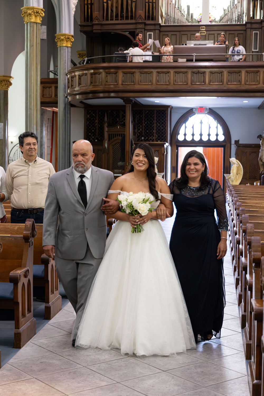 A wedding ceremony taking place in a traditional church with wooden pews.
