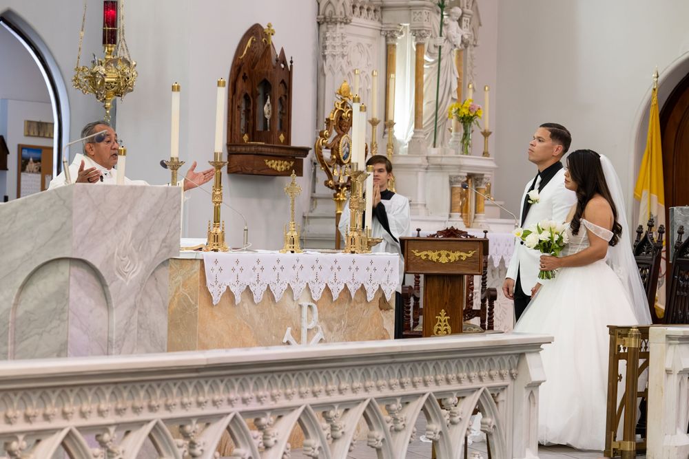 Church sanctuary with decorative white marble altar and religious statues.