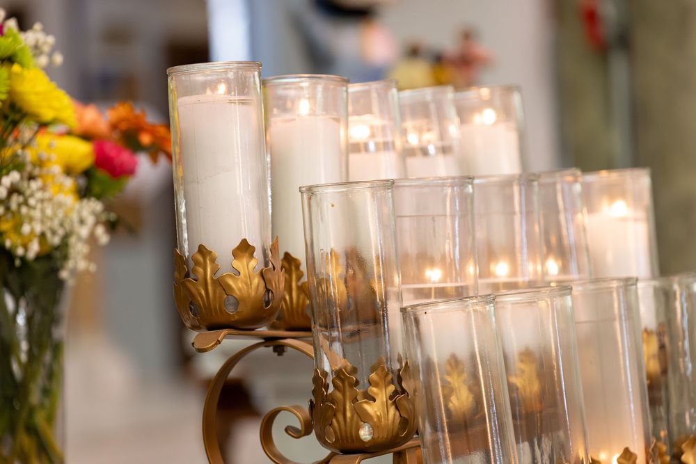 Glass candle holders with glowing flames creating an intimate atmosphere at an elegant wedding reception.