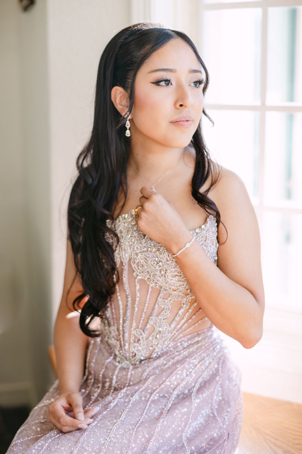 A series of elegant portraits showing someone in a sparkly pink evening gown posing gracefully by a window.