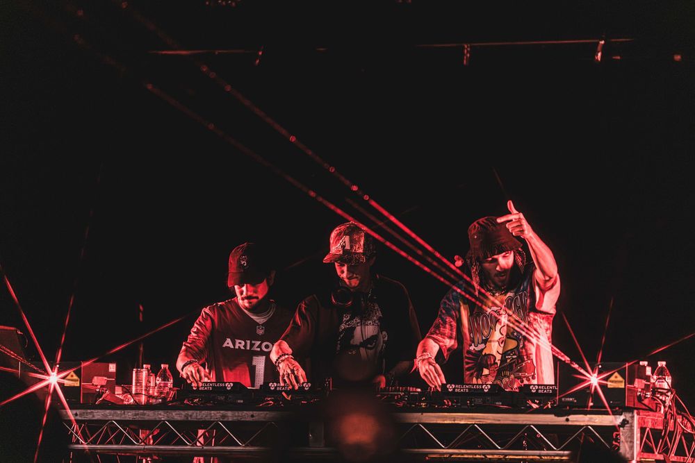 DJs perform on stage bathed in dramatic red lighting during a nightclub performance.