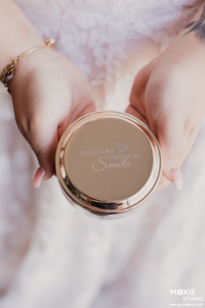 Close-up shots of a rose gold compact mirror being held against a soft pink background.
