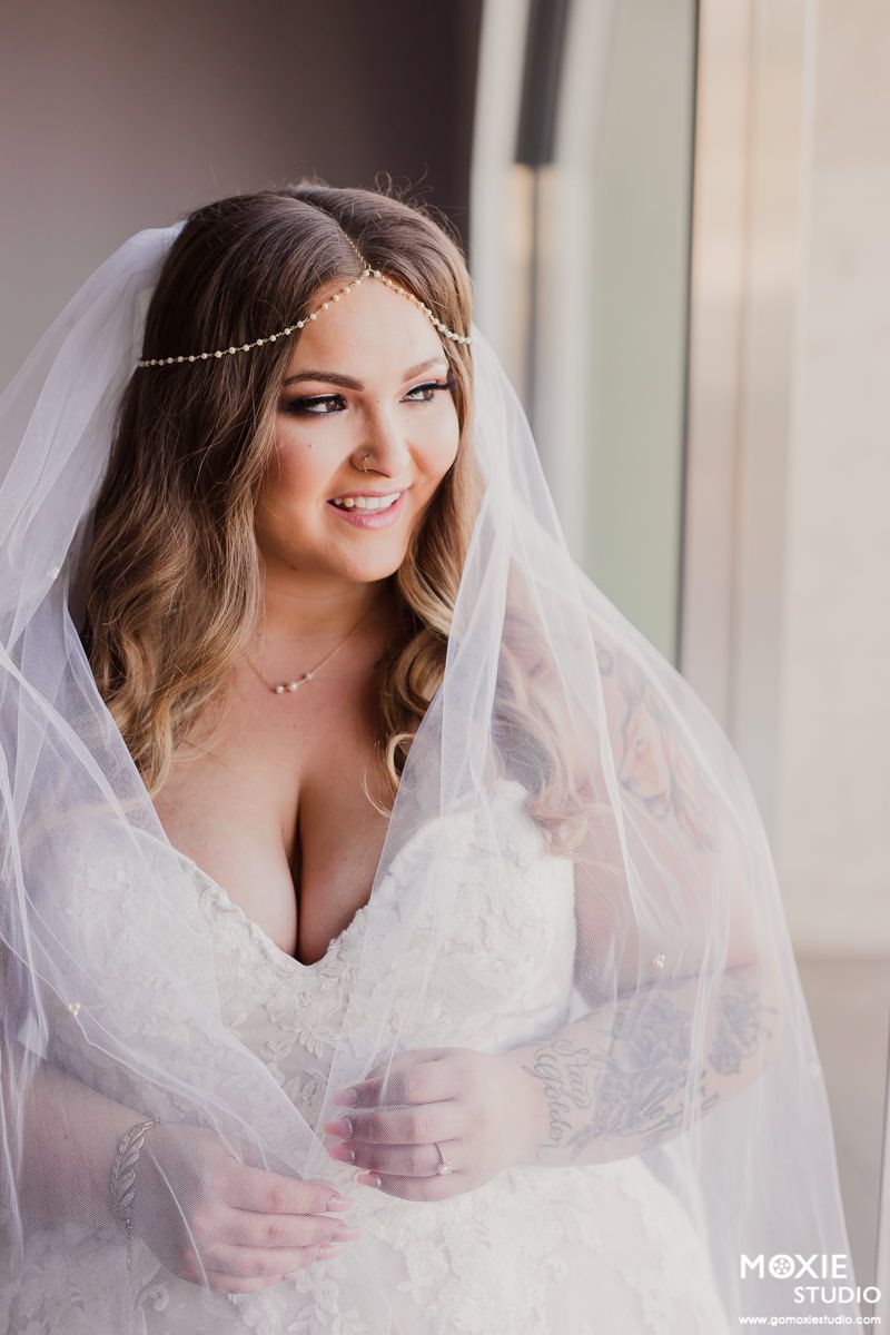 A bride wearing a white lace dress and veil poses with a delicate headpiece in a series of elegant portraits.