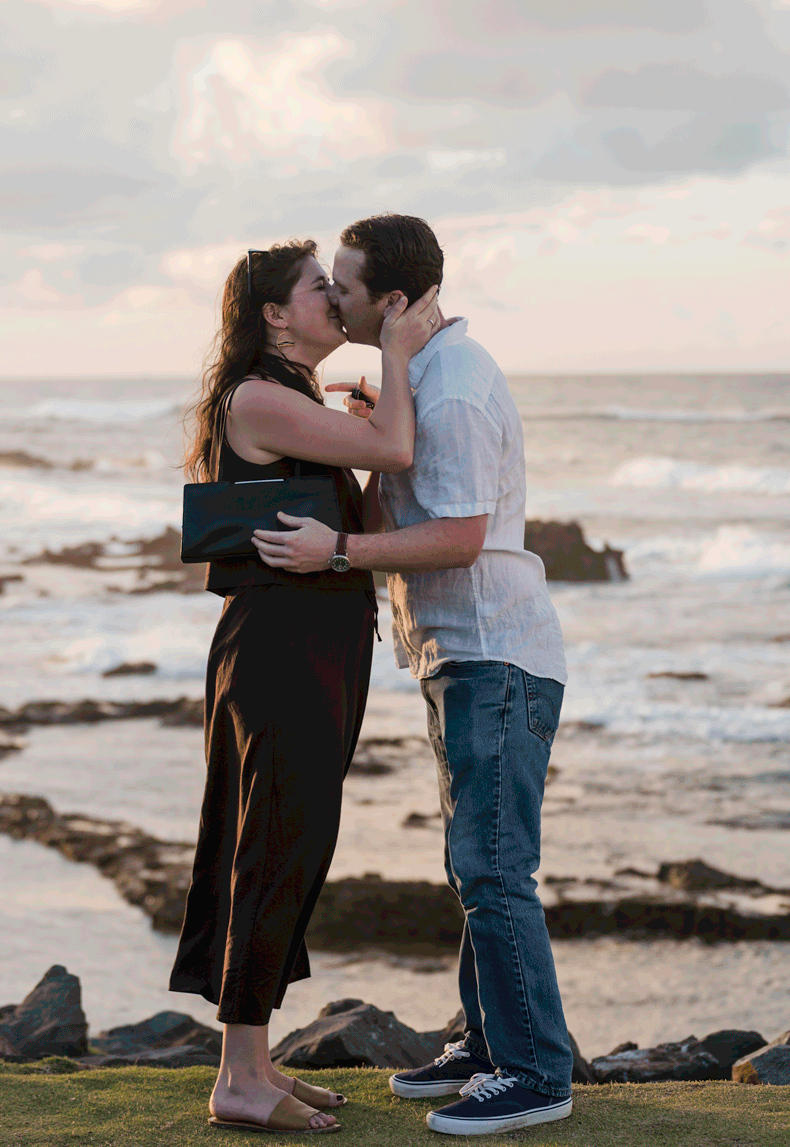 Couple embracing on rocky shoreline during engagement session in Puerto Rico