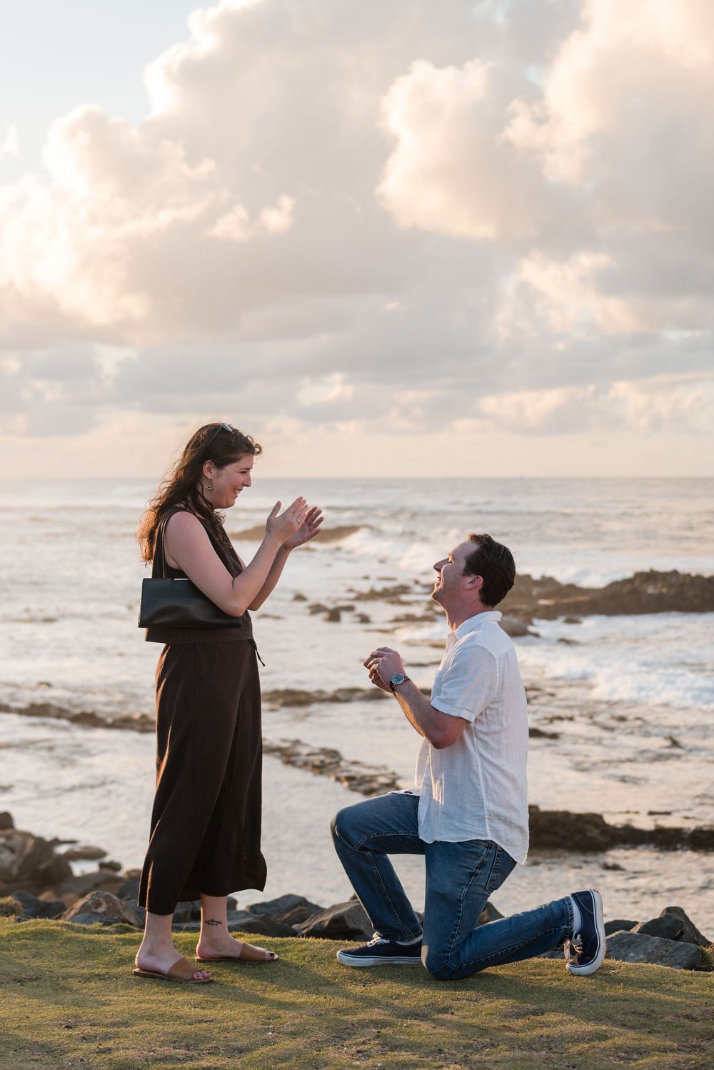 Man kneeling during surprise proposal on rocky beach in Puerto Rico