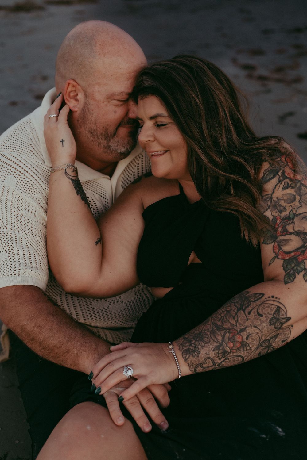 Intimate couple in dark moody setting sharing tender moments in a series of romantic photos showing tattoos and connection.