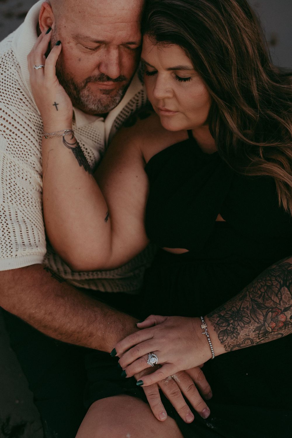Intimate couple in cozy sweaters sharing tender moments in moody black and white photography series.