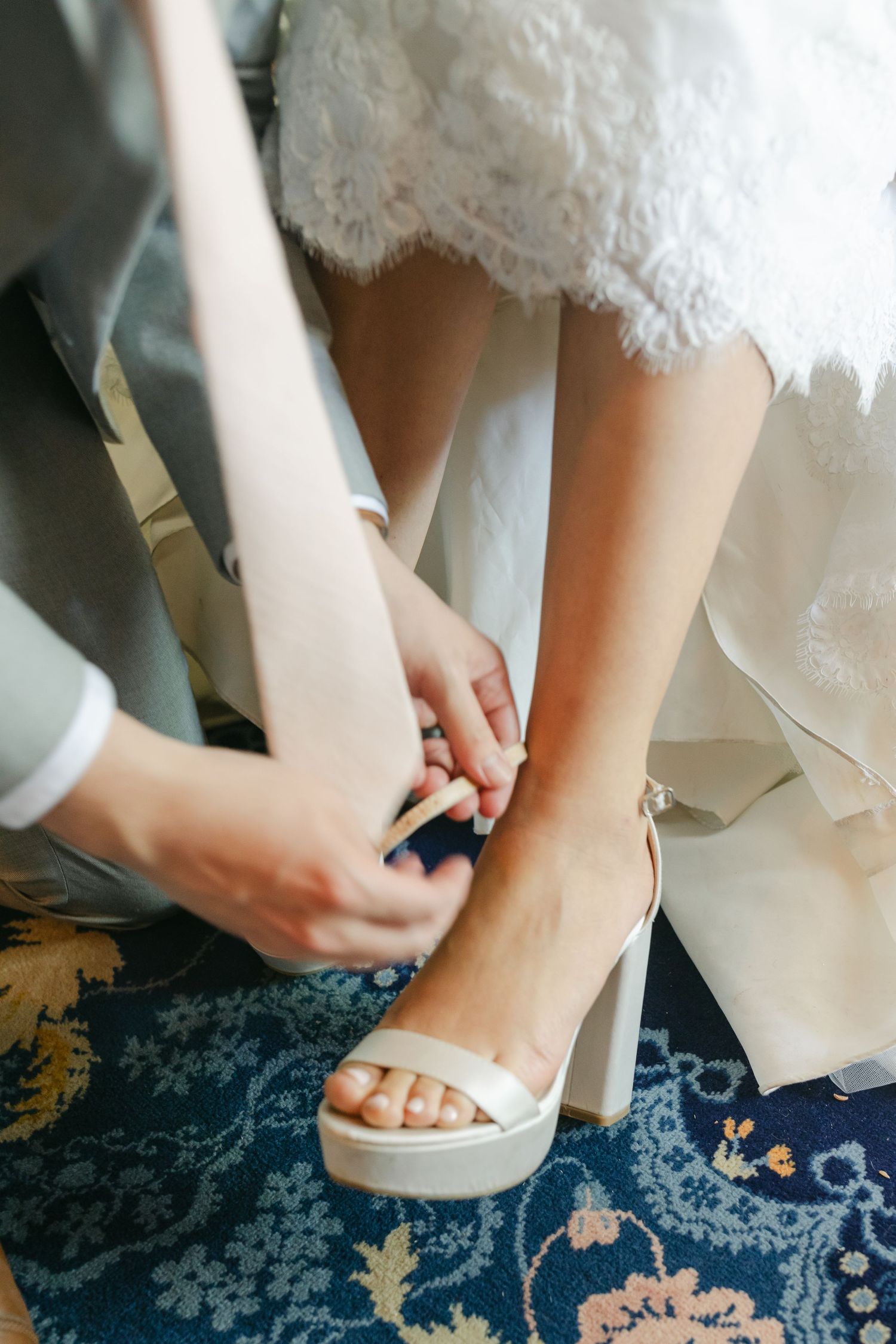 Bridge getting help with shoes from groom shot at the McHenry Mansion captured by Chelsee Rawe Photography