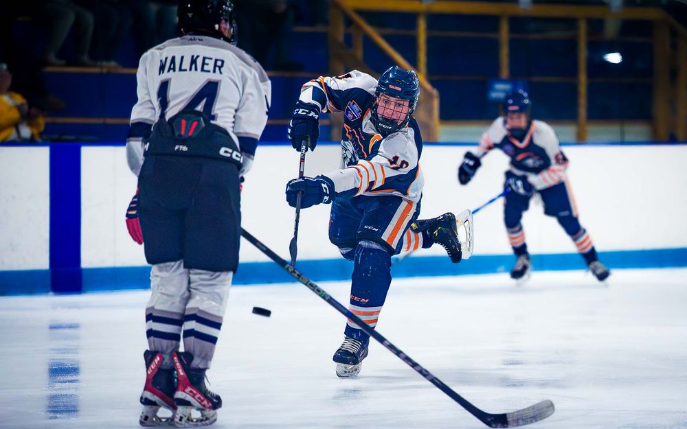 Hershey Trojans player winds up for a slapshot as a Dallastown defender approaches