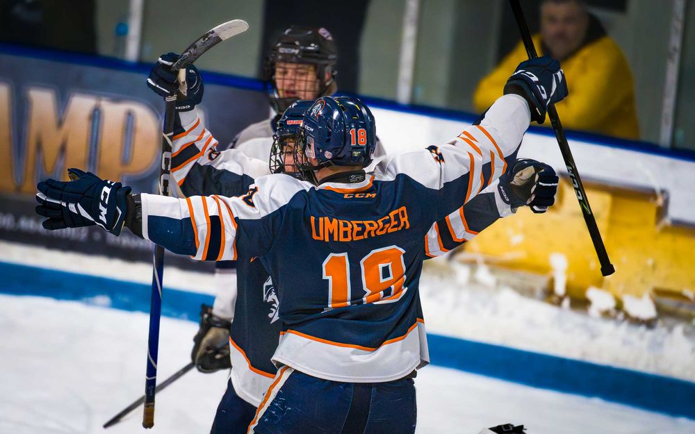 Trojans player #19 celebrates a goal with a teammate, arms outstretched in excitement by SportsFox Photography, Hershey, PA