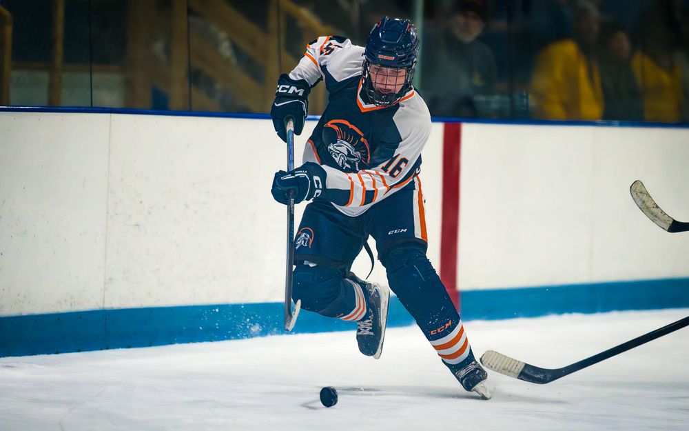 Trojans player skates quickly up the ice, stickhandling and looking ahead by SportsFox Photography, Hershey, PA