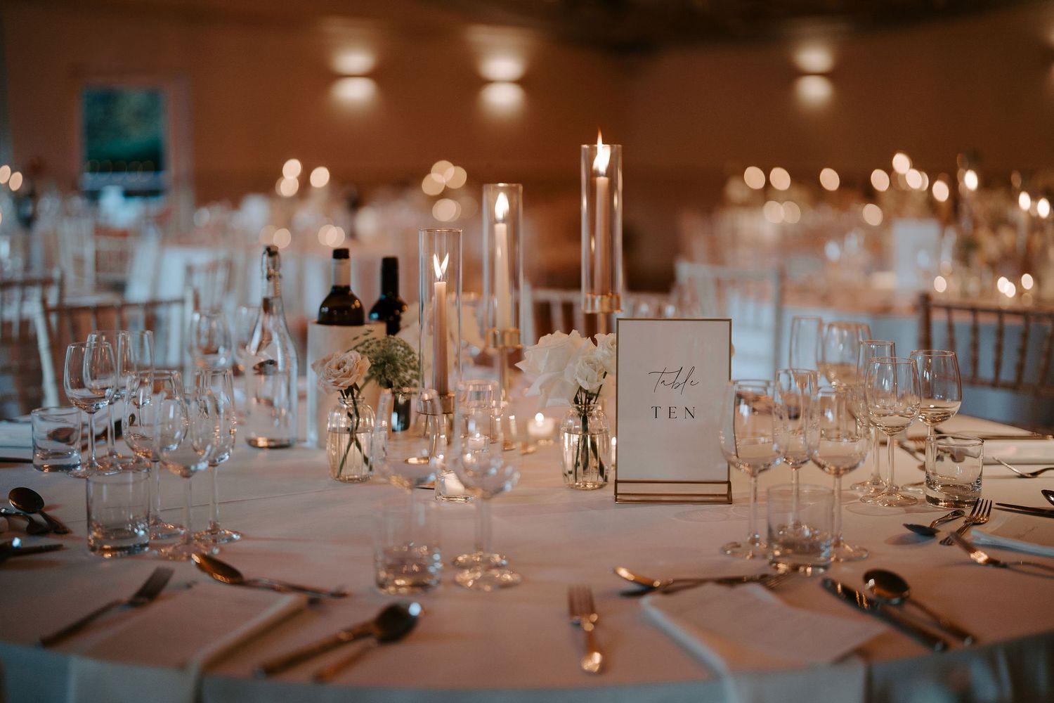 candles and floral arrangements on table in marquee at Iscoyd park