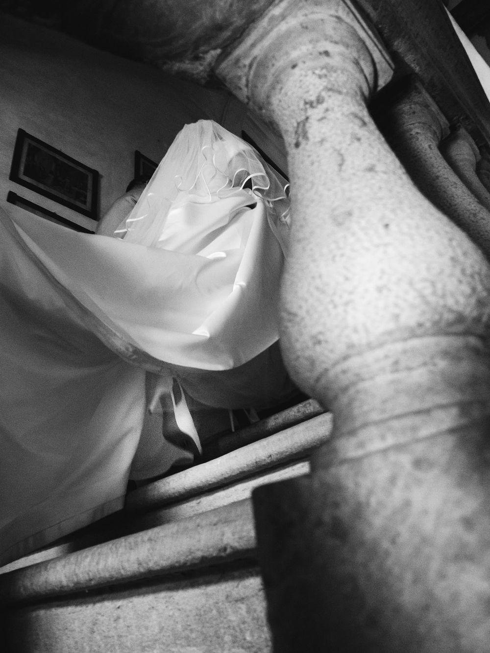 Fotografia spontanea che ritrae la sposa che percorre le scale per raggiungere la sala della cerimonia di nozze, in bianco e nero