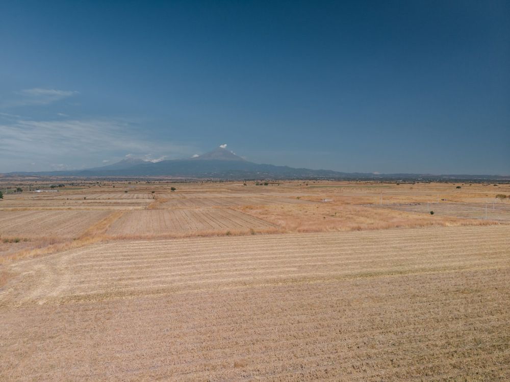 A series of aerial photos showing vast agricultural fields with curved contour lines stretching across rolling terrain.