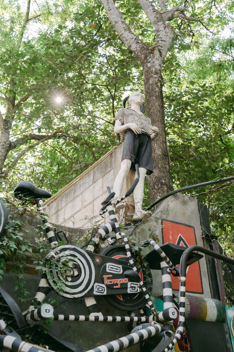 Black and white striped artistic installation mounted on trees with geometric patterns and circular designs.
