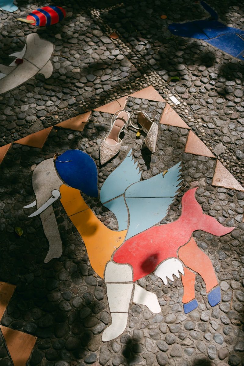 Colorful broken mosaic tiles form an abstract pattern on a stone floor.